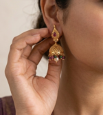 traditional gold-plated jhumka earrings featuring ruby-red stone studs and dangling pearl and multi-colored bead accents. - Image 2