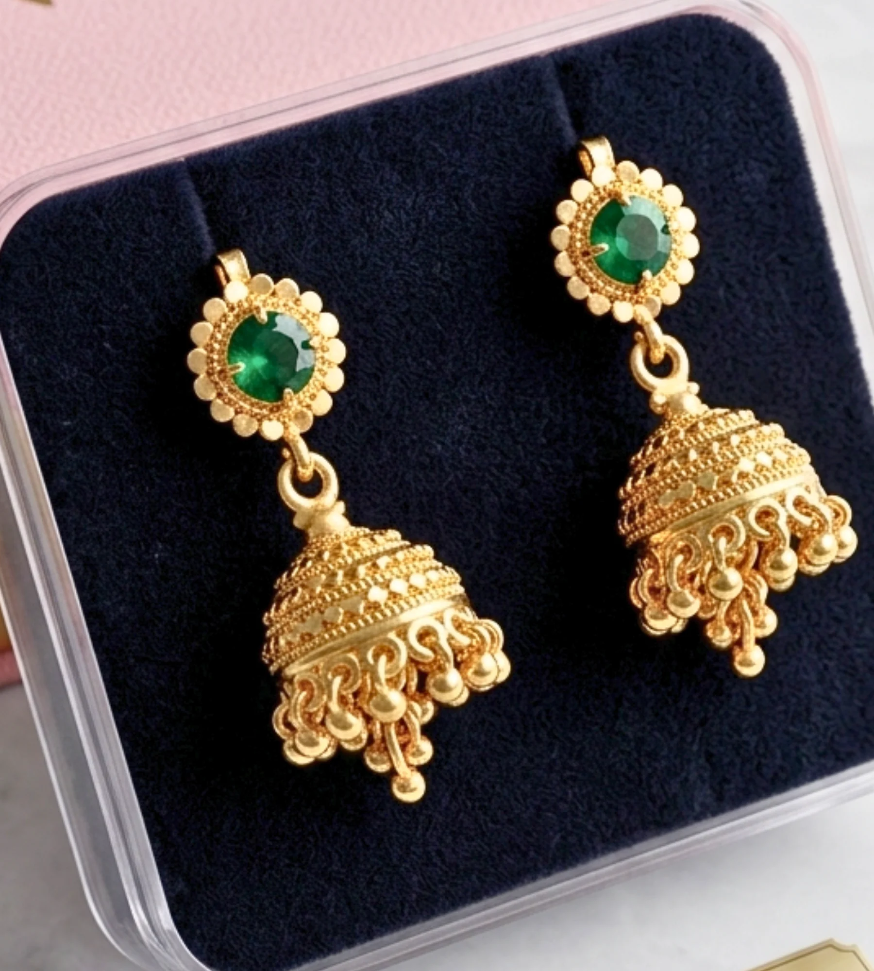 1000358565 Gold-finish jhumka earring featuring a floral stud set with a green stone and a bell-shaped drop with hanging bead details. - Image 1