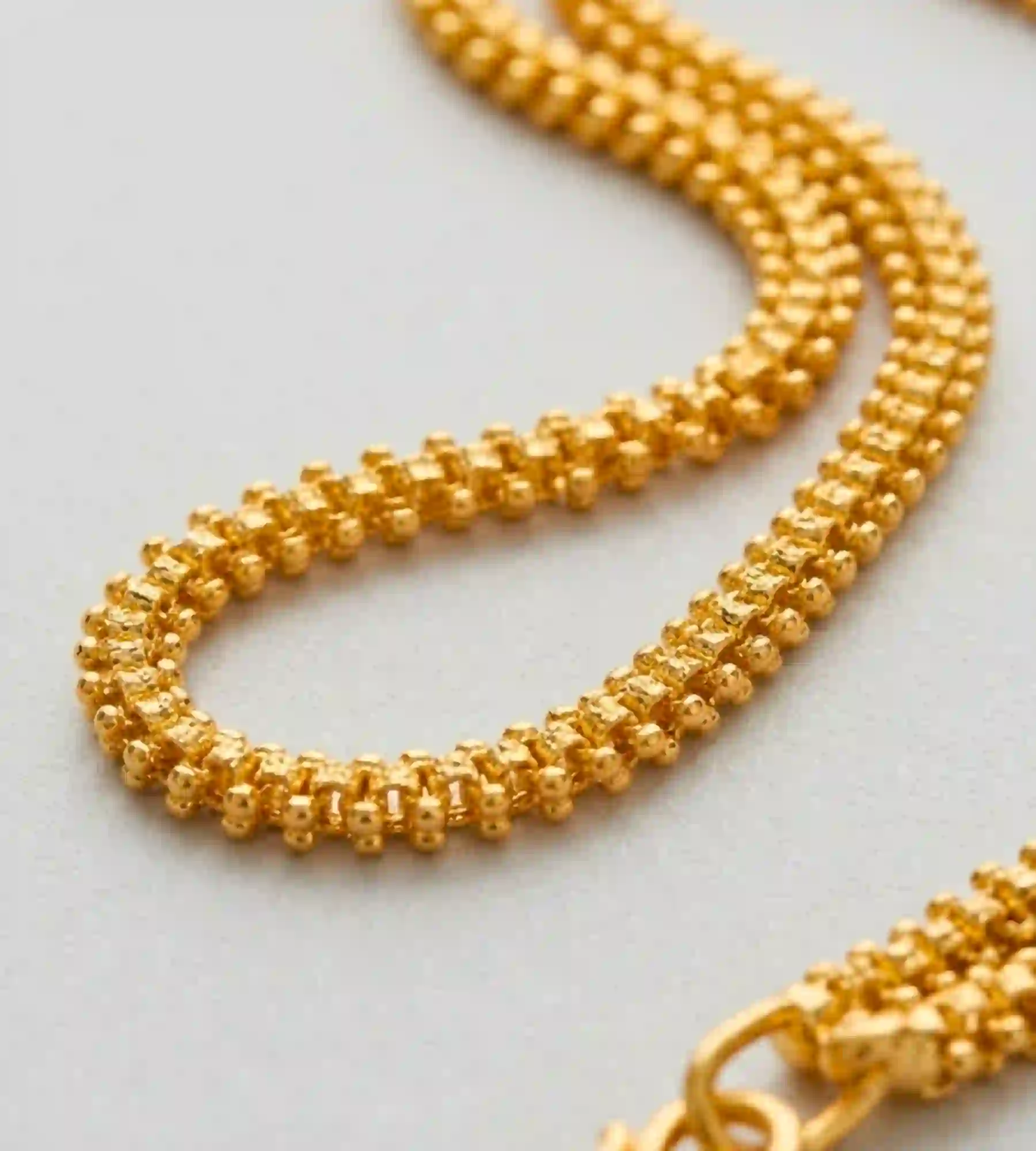 1000358594 Gold-beaded chain, resembling textured link designs - Image 1