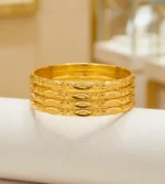 Gold- plated bangles featuring an embossed oval and floral motif (Set of 4)