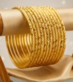Gold bangles featuring intricate diamond-cut and geometric etched patterns (set of 12)
