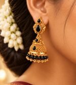 Gold-tone jhumkas with latticework domes, black teardrop stones, and black beads. - Image 2